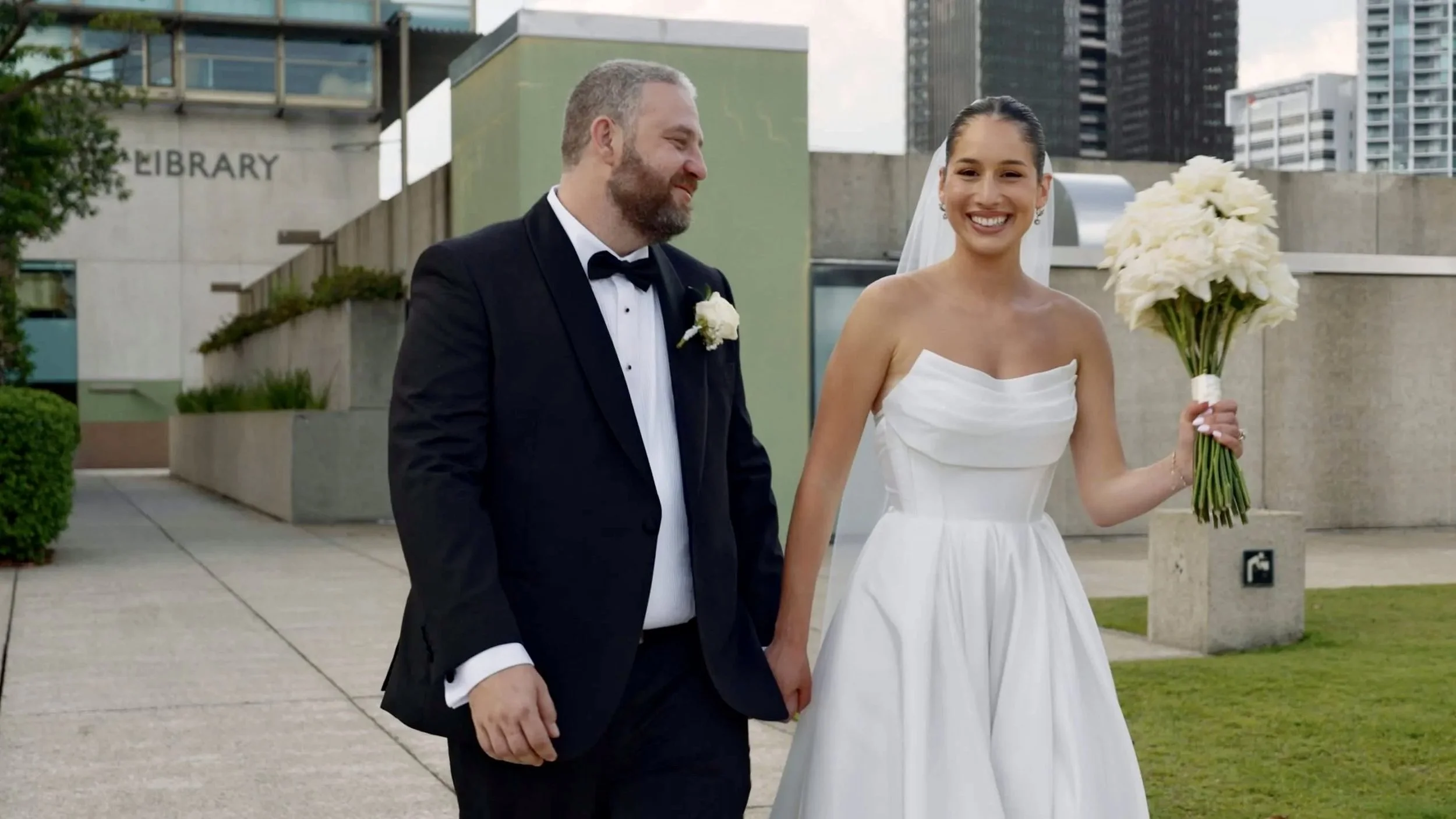 Sera holding Paul's hand with her genuine smell walking while look at the Brisbane wedding photographer Whistler Li