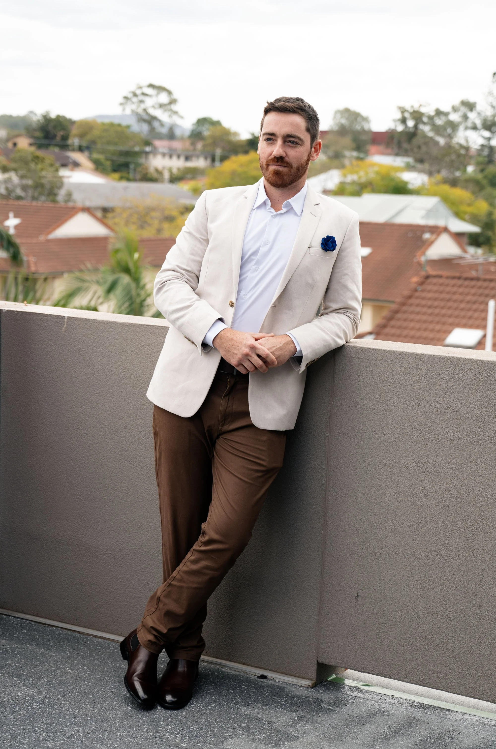 Groom Thomas leaning casually, exuding a relaxed and confident vibe as he enjoys a moment before or during the wedding celebration