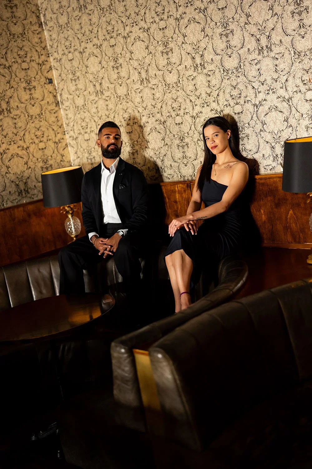 Jay and Jasmin both sitting on the arm of the sofa and look at the Brisbane wedding photographer Whistler Li