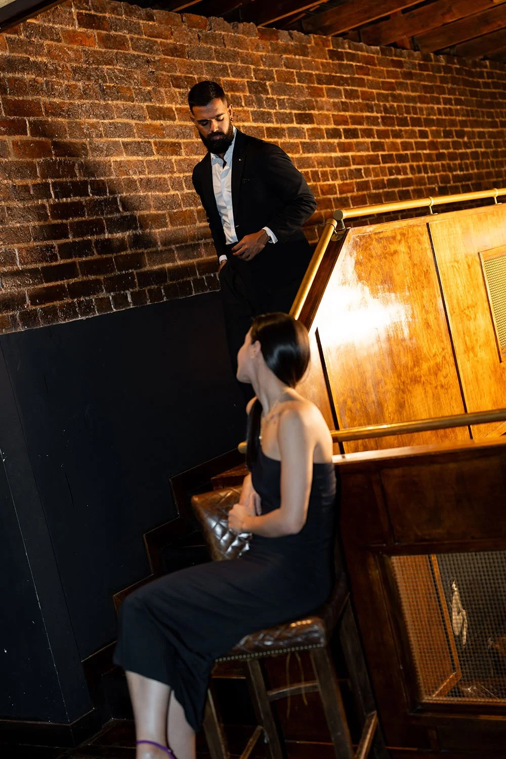 Jasmin sitting on a stool and look at Jay walking towards to her