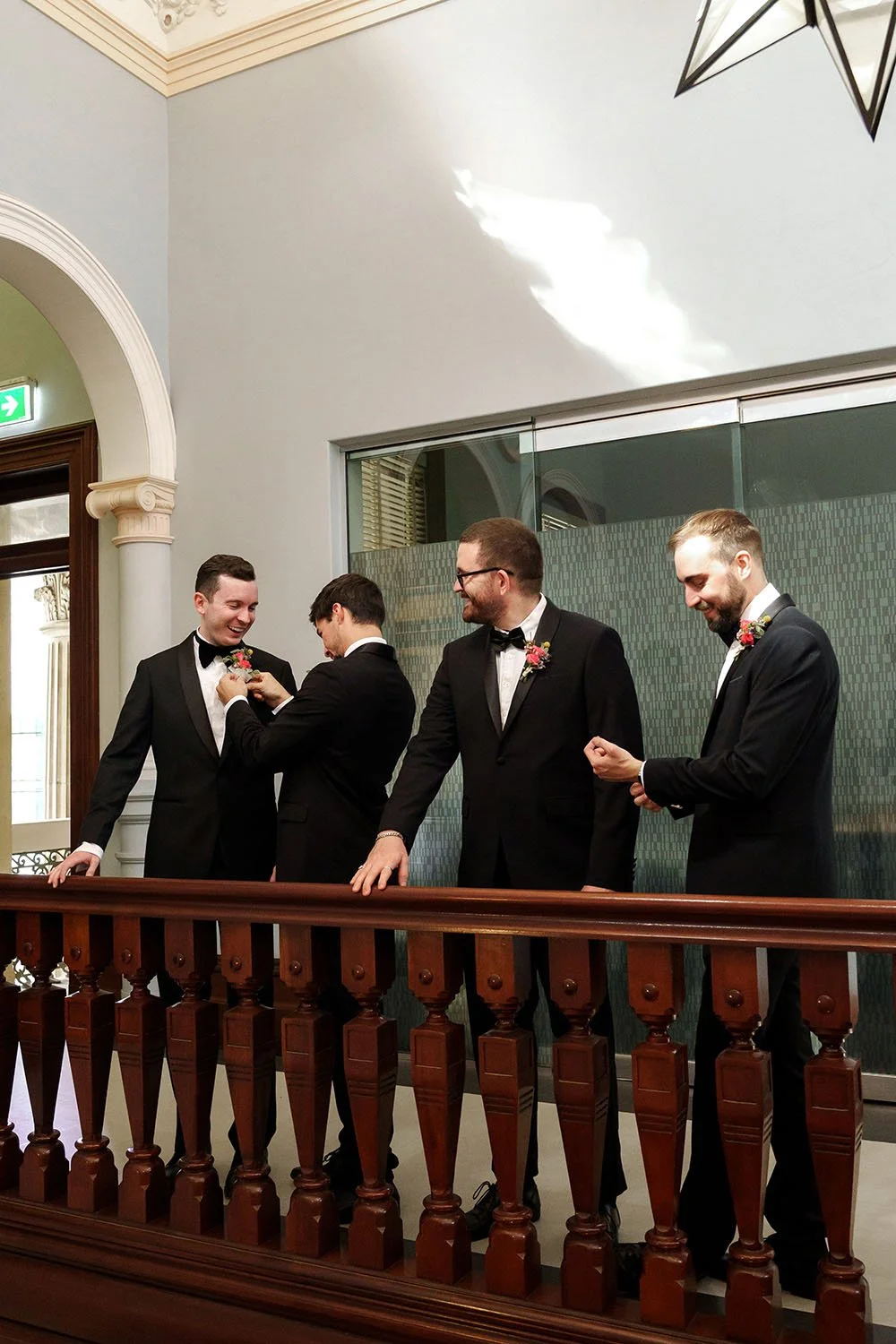 groom Cliffe's best man put on the pocket flower for him, and other groomsmen adjusting their shirt of cufflinks by them self