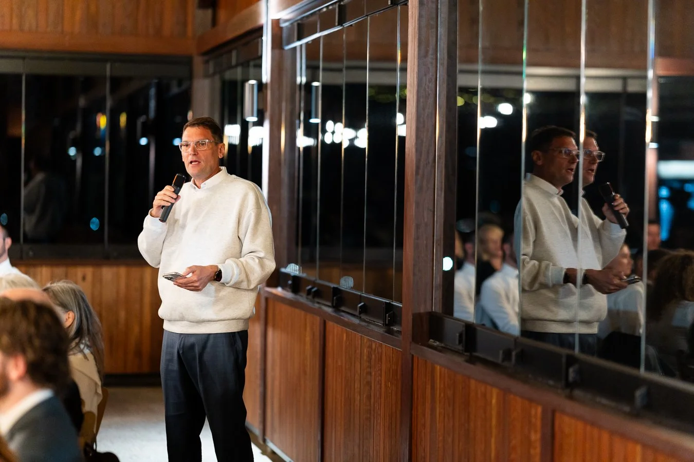 groom Ben's father speak on a mic while look at the guests