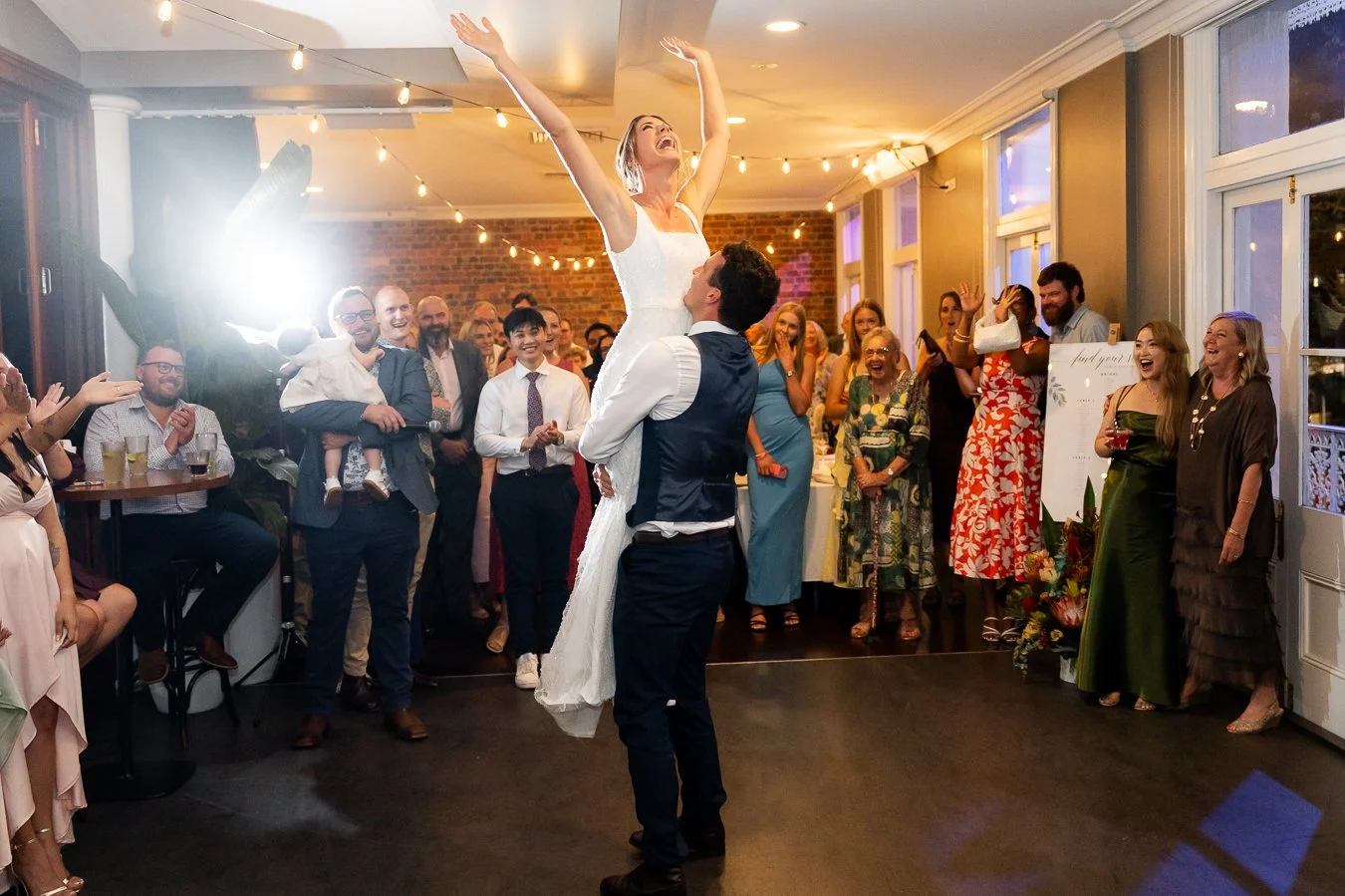 groom Giordan lifting bride Sonya up and her hands in air make all guests cheers