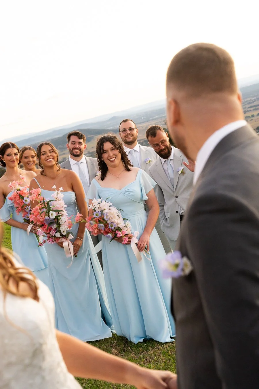 Chiarra and ben look to their bridal party with smell