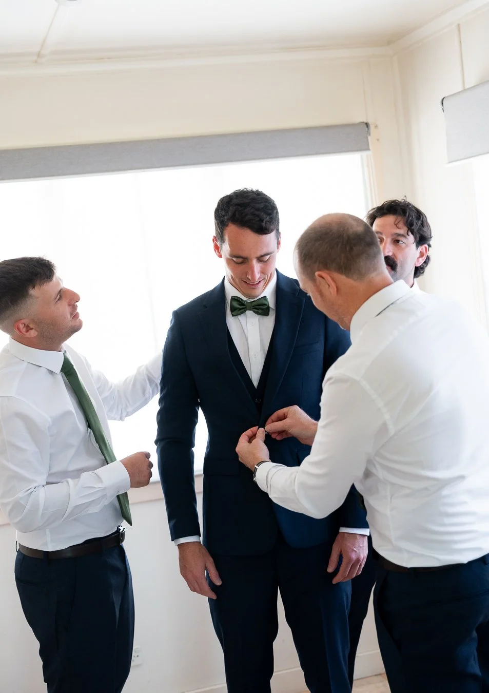 best man helped the groom fasten his suit buttons