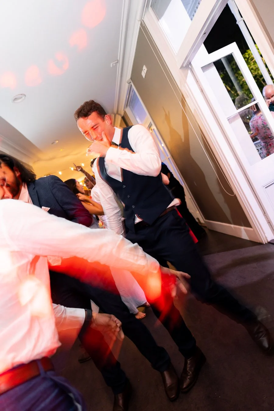 groom Giordan use hand cover his face make a surprise face while dancing with guests