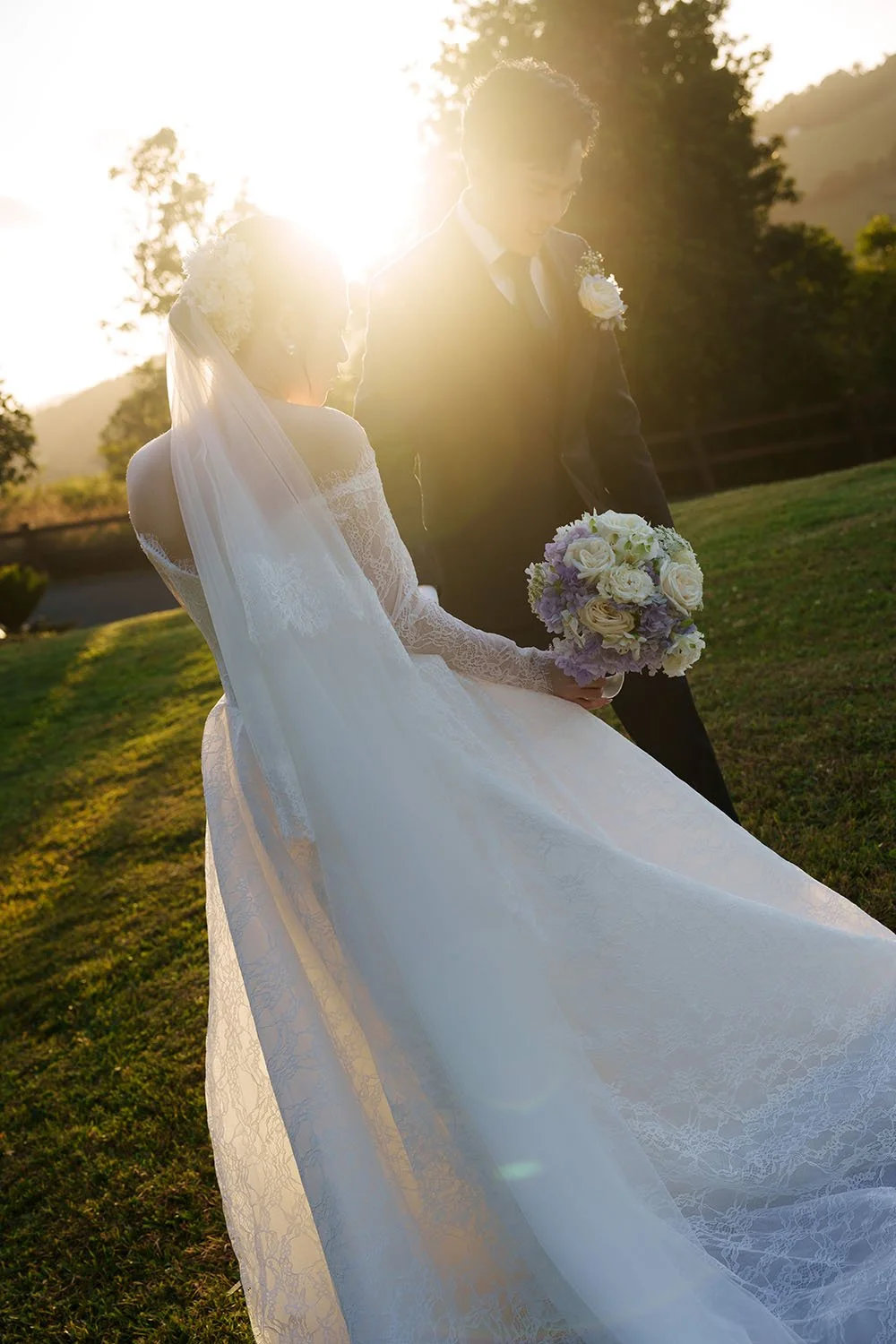 Lisa and Michael look down together with a sunset shying through them 