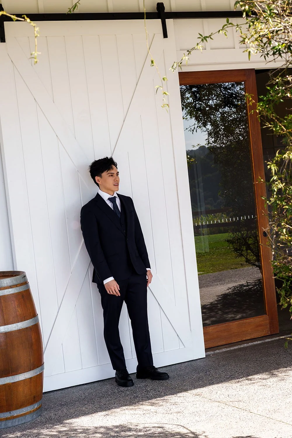 Michael leaning back to a white barn door and look straight ahead