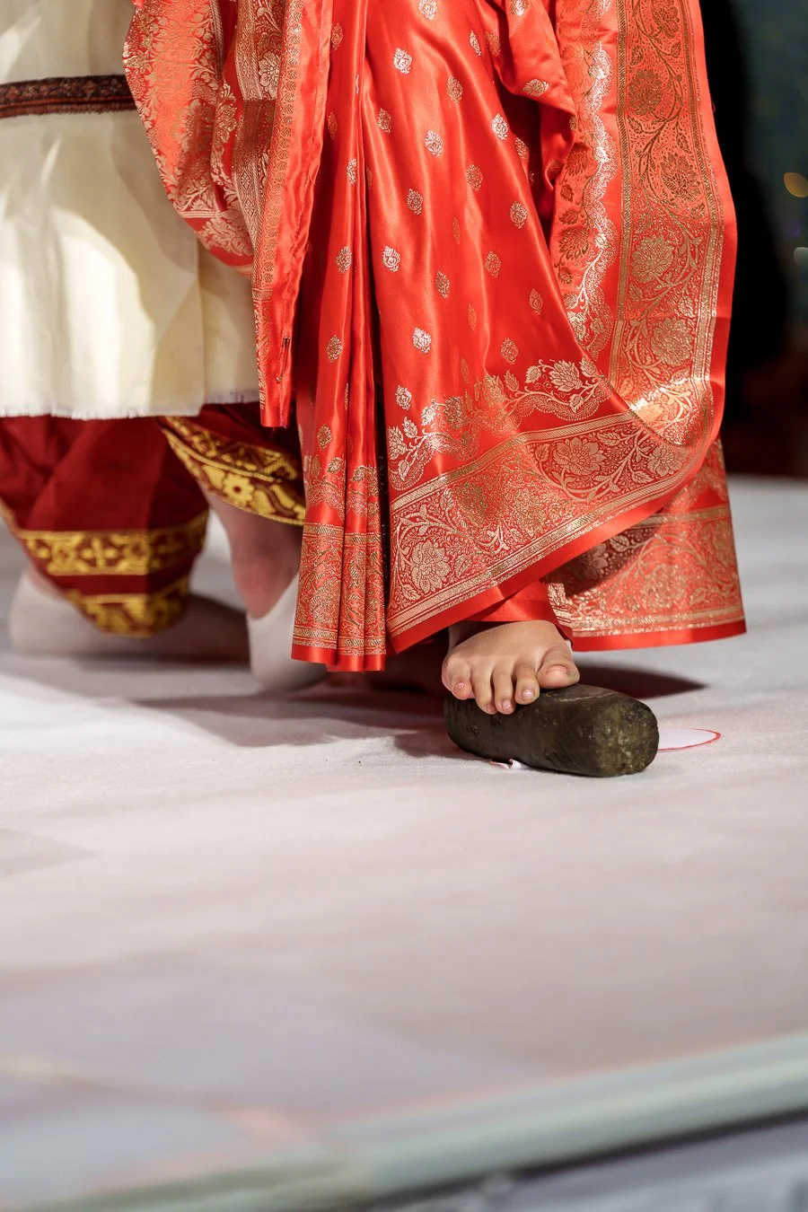 Amrita's feet step on a stone when they doing the seven steps for traditional hindu wedding