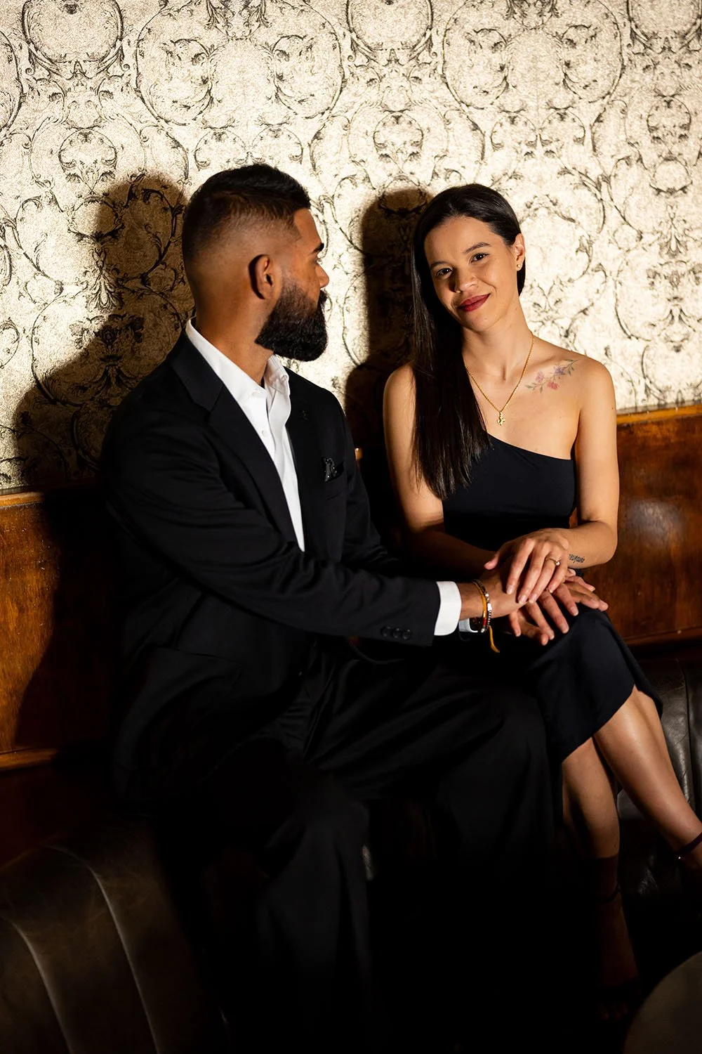 Jay hold Jasmin's hand while she look at the camera