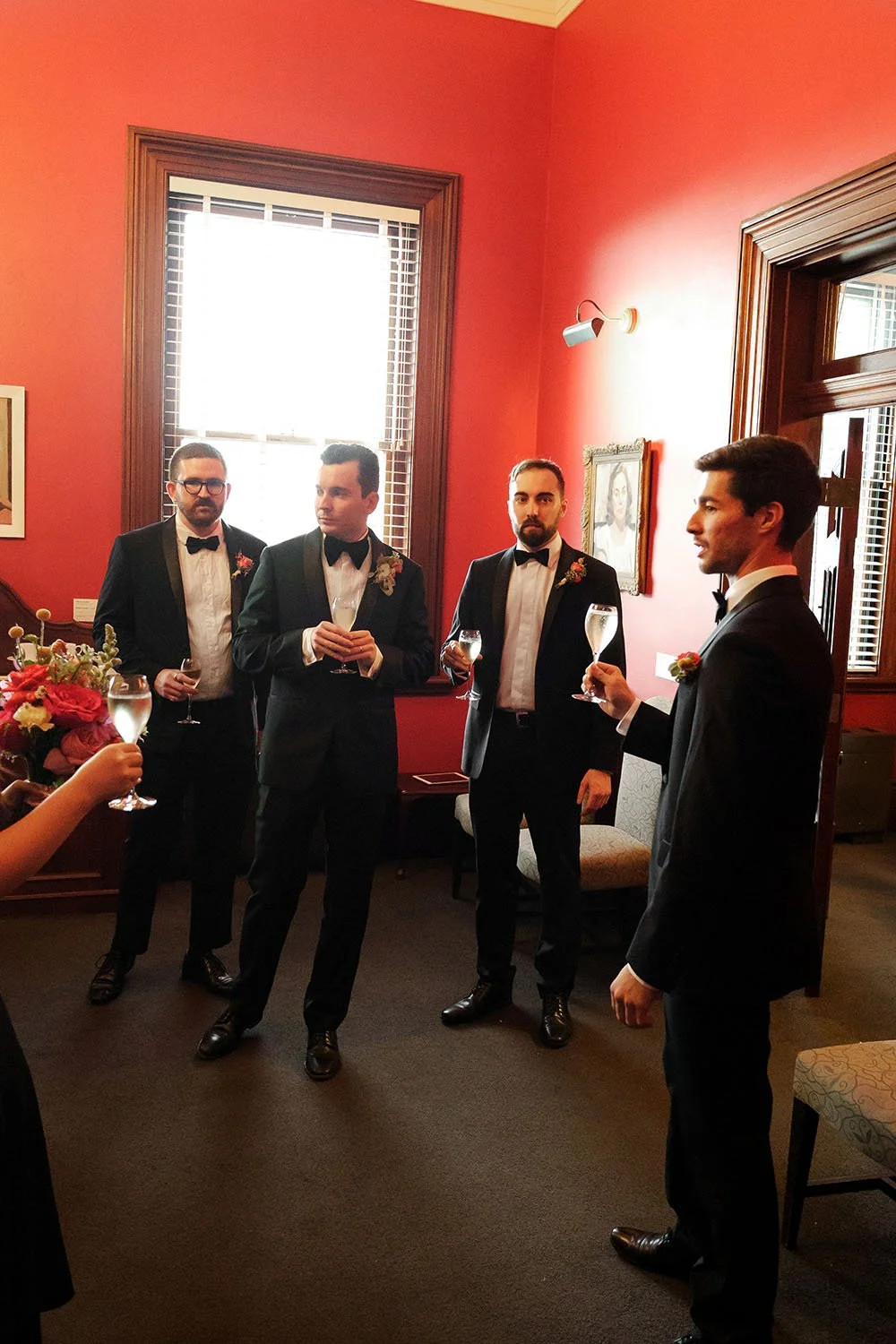 groom Cliffe with his groomsmen holding glasses of champagne