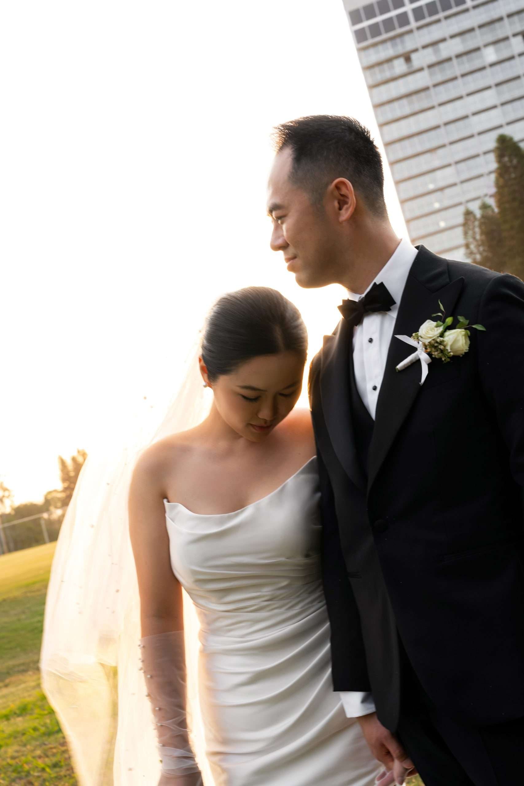 bride Wendy try to leaning on groom Alex's shoulder while they holding hands
