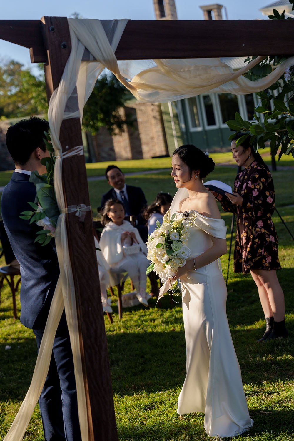 bride Flora holding a flower under a arch
