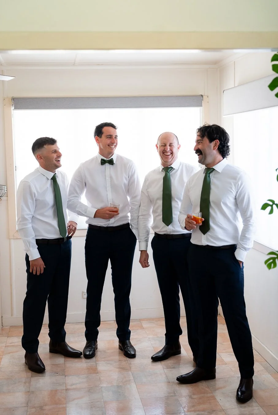 The groom and his groomsmen stood together, chatting and laughing.