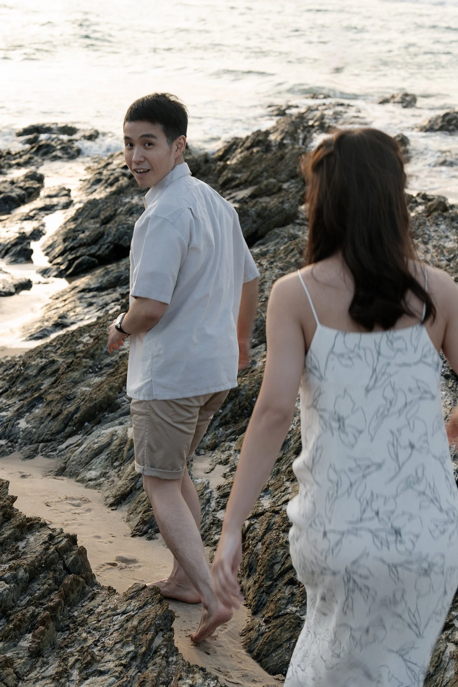 Paul look at the Brisbane wedding photographer when walking towards to the ocean and Krystel follow him