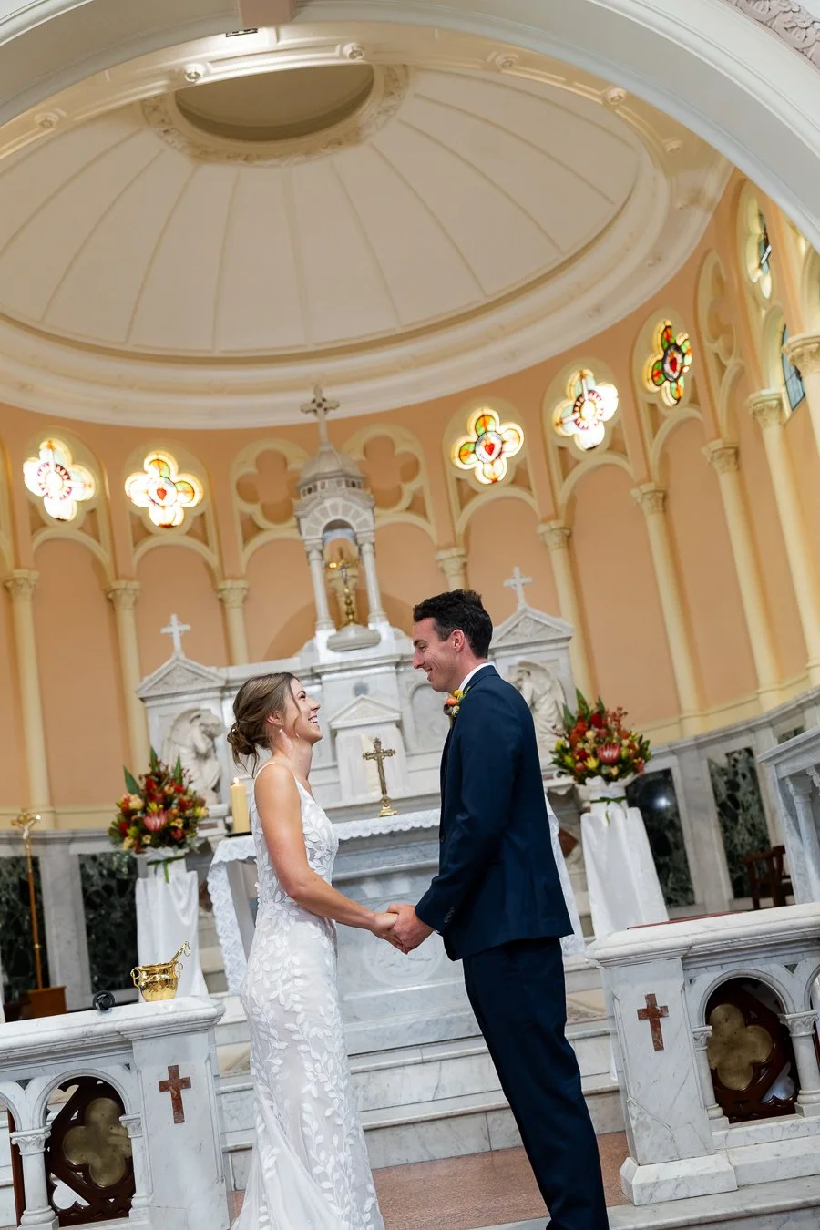 The bride and groom held hands and smiled at each other.