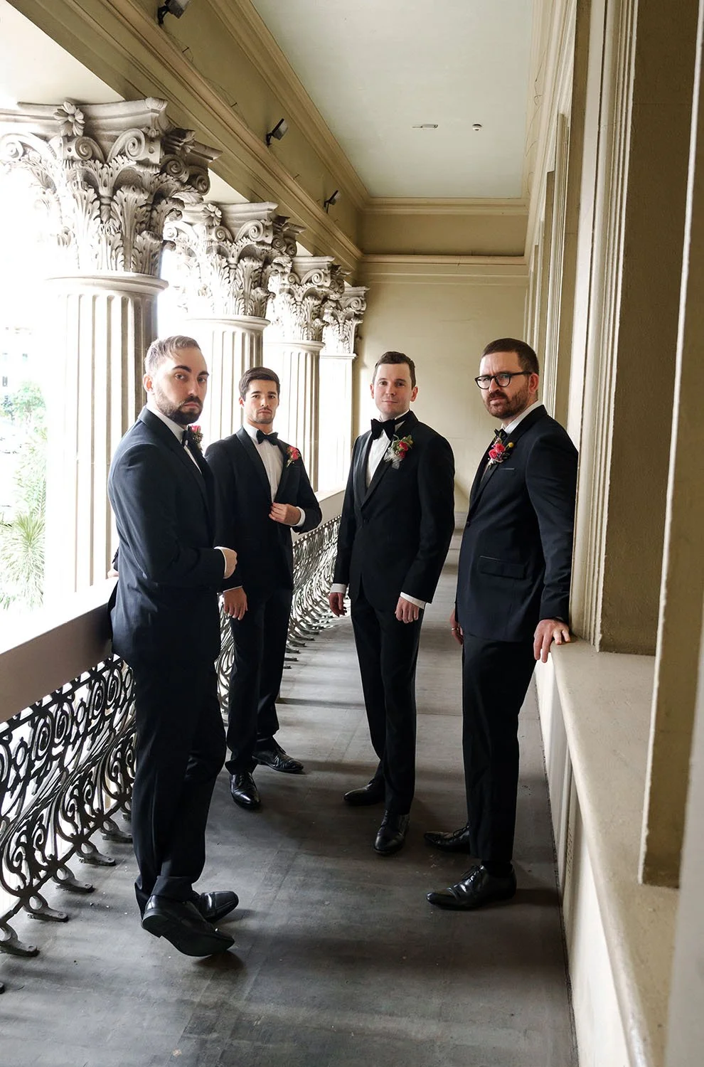 groom Cliffe and his groomsmen look at the Brisbane wedding photographer Whistler Li with no smell in the baloney of customs house