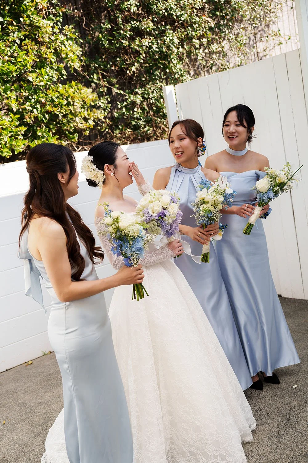 Lisa's brides mate making her laughing, and Lisa hand covering her face 