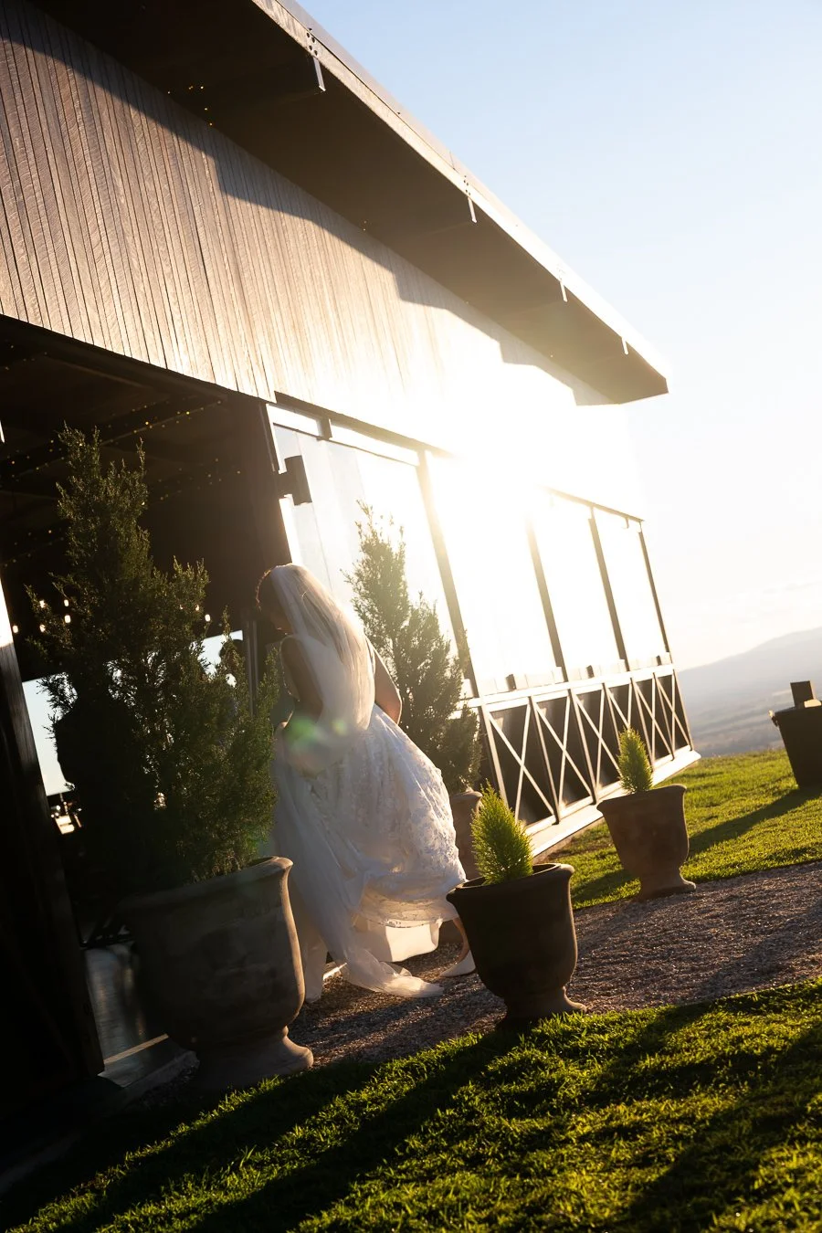 bride holding her dress walk into her reception room in Western Ridge