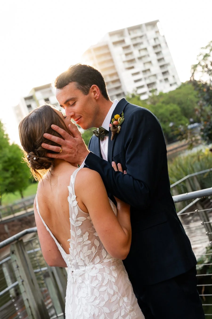 groom Giordan two hands holding bride Sonya's face and nose touching