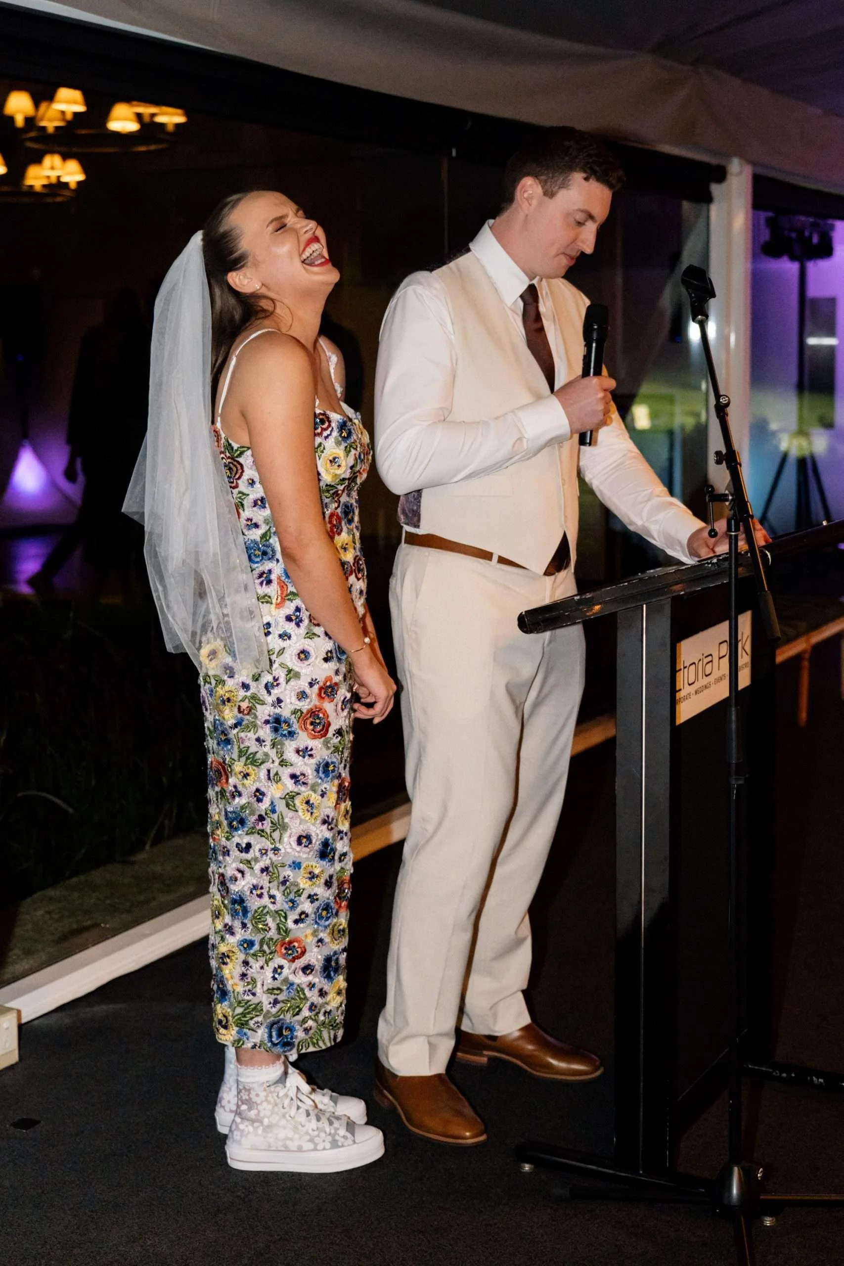 Charlotte laughing while groom Jack speak on a mic