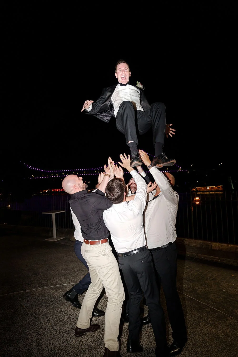 5 males throw groom Cliffe to the air and groom excited