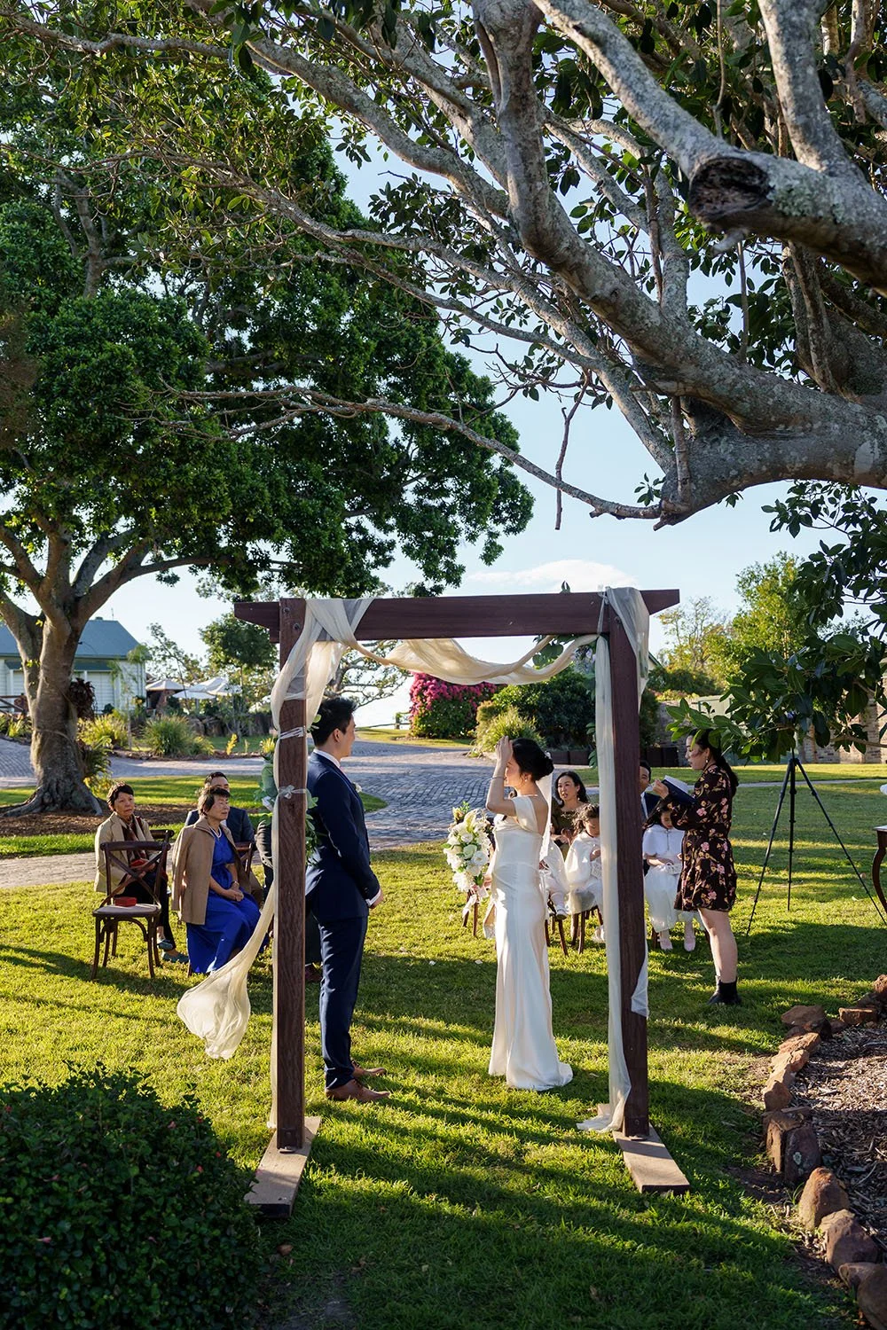 wedding ceremony, Eric and Flora stand face to each other and guest sitting behind them