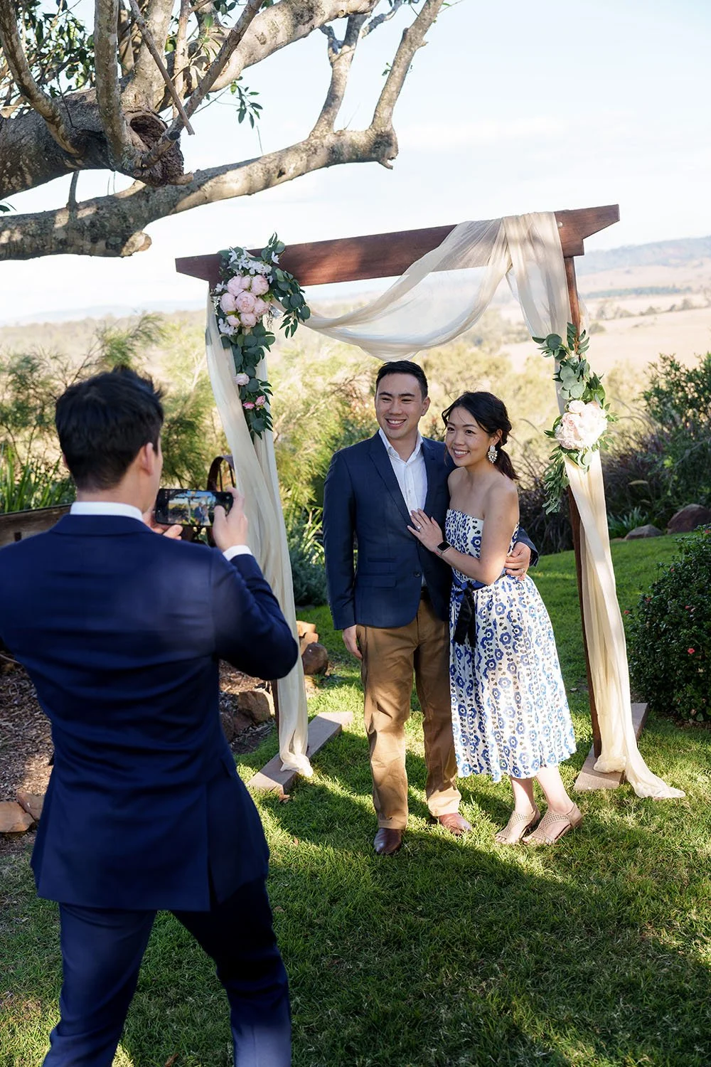 groom Eric taking photos for his sister and brother in law use phone