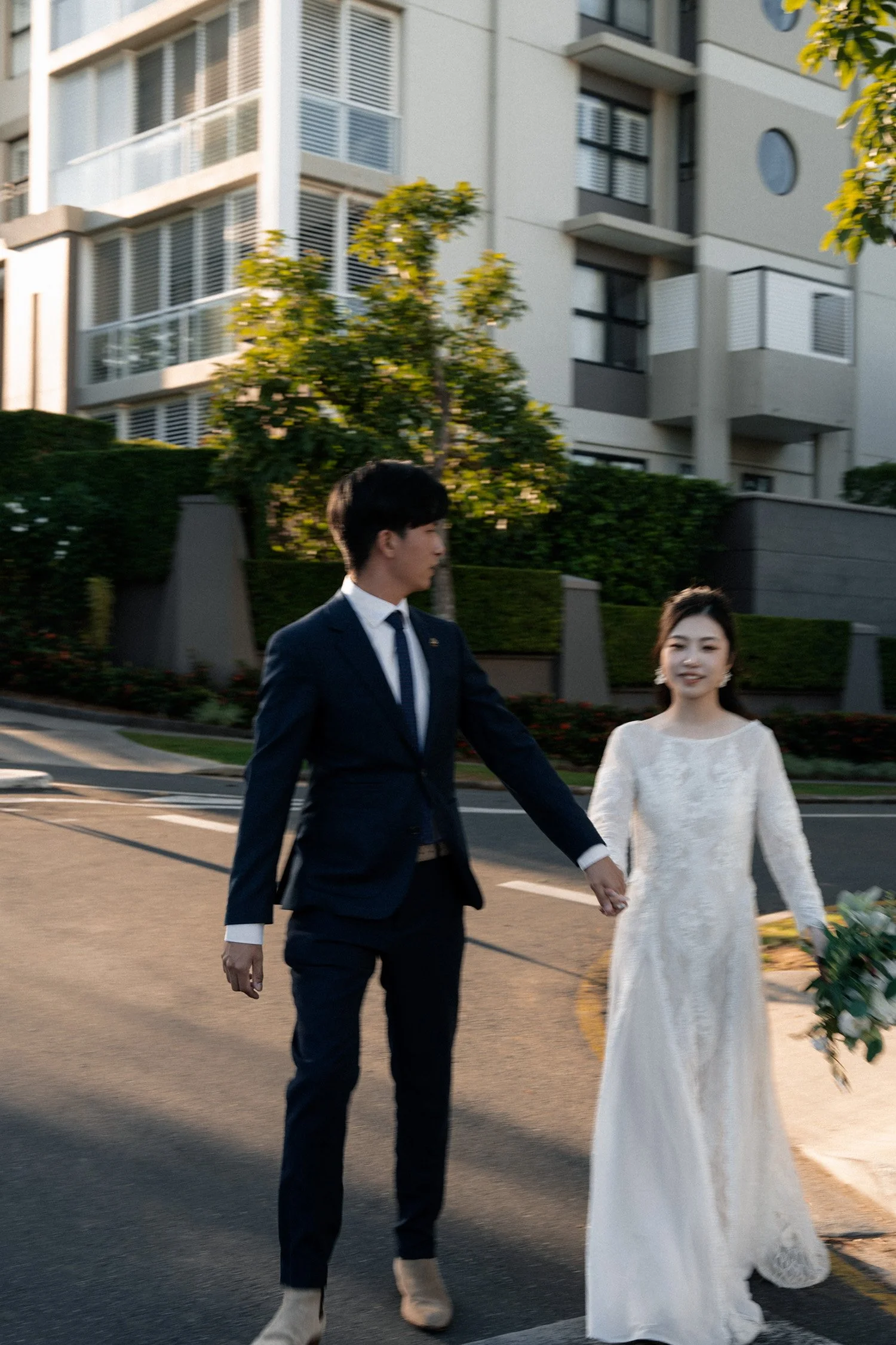 groom Leo look back to bride Cassie when they holding hands walking together