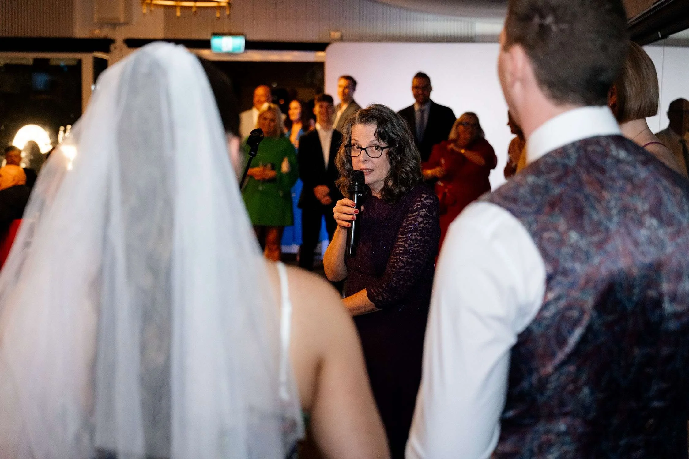 groom's mother making a speech, with his sister, bride and groom stand next to her