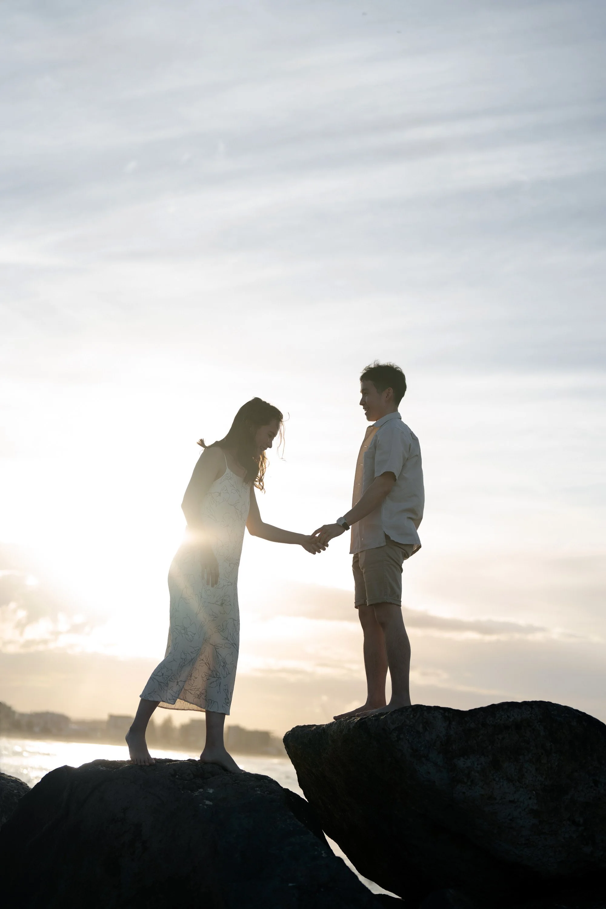 Paul grab Krystel's hand when they standing on the top of the rock in Gold Coast