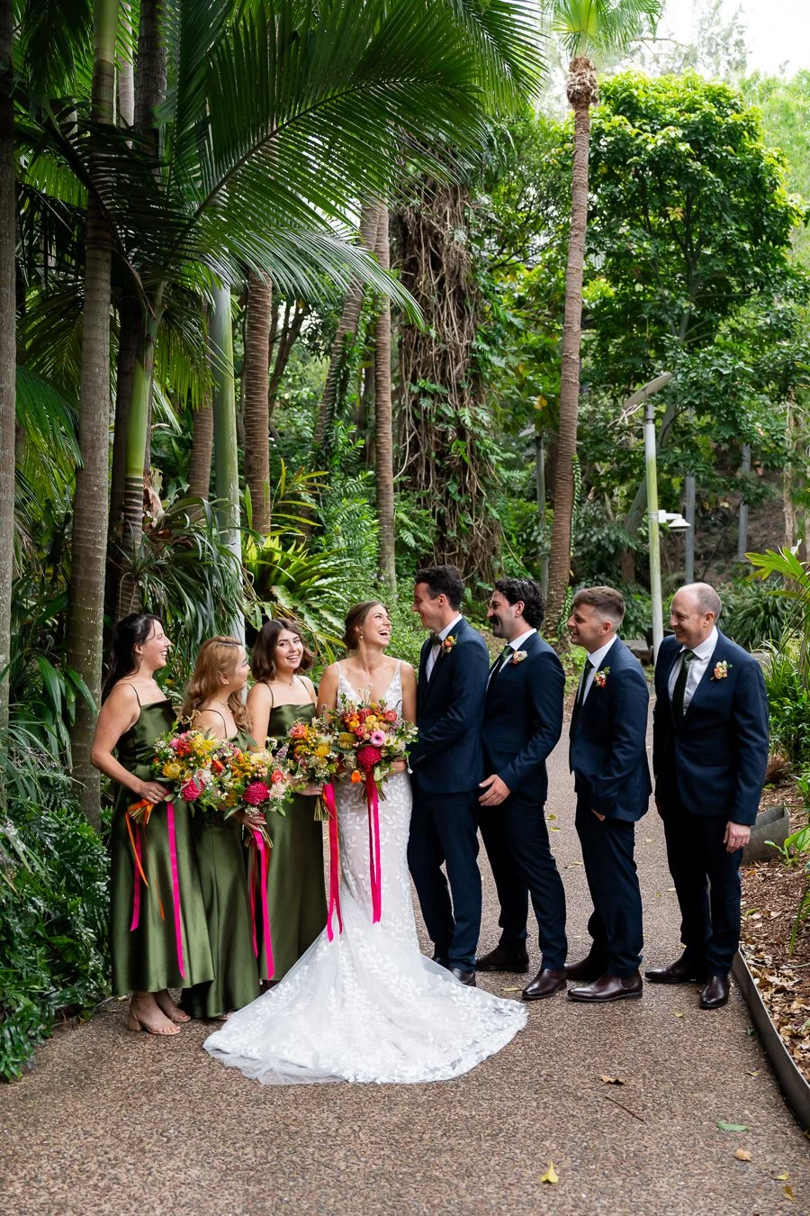 the groomsmen and bridesmaids happily chat with bride and groom, standing in a line.