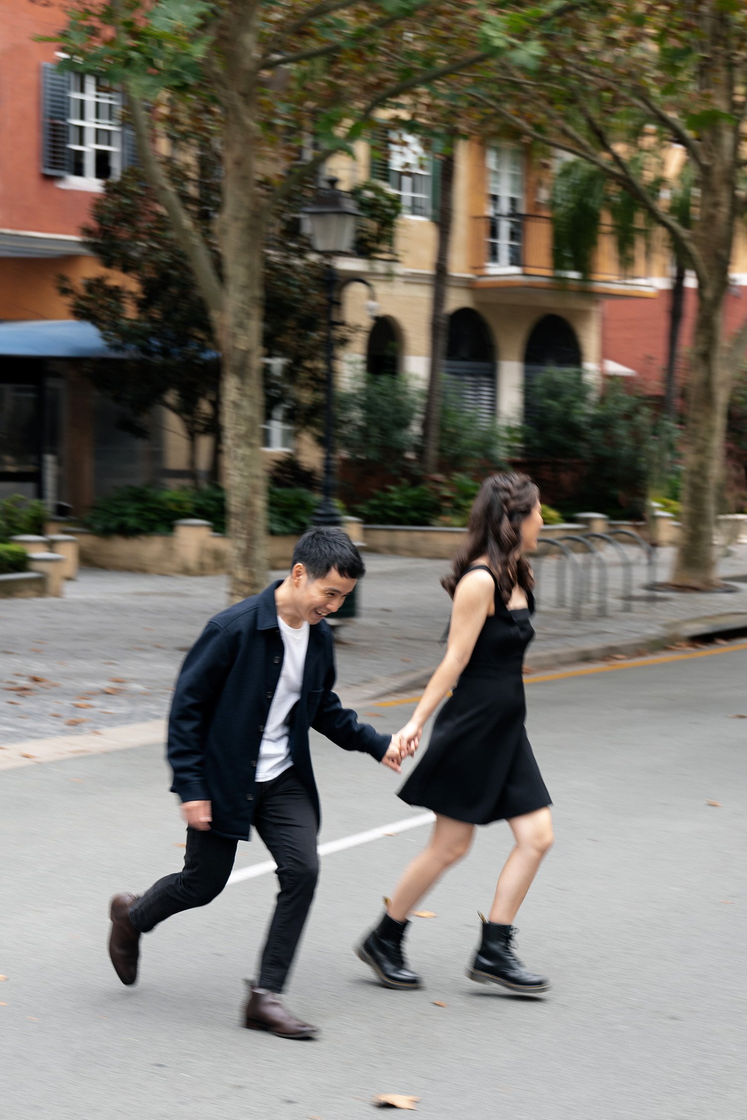 Paul holding Krystel's hand and they both passing the road in in Emerald Lakes Village in their engagement photoshoot session