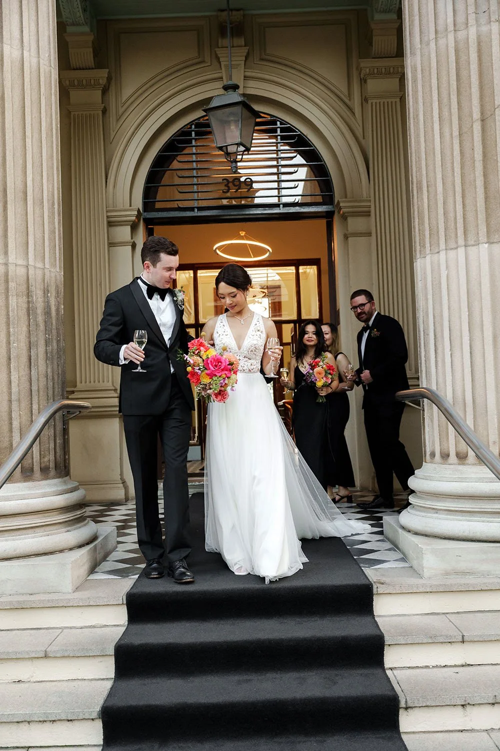 bride and groom walking down the stairs, bridal party follow