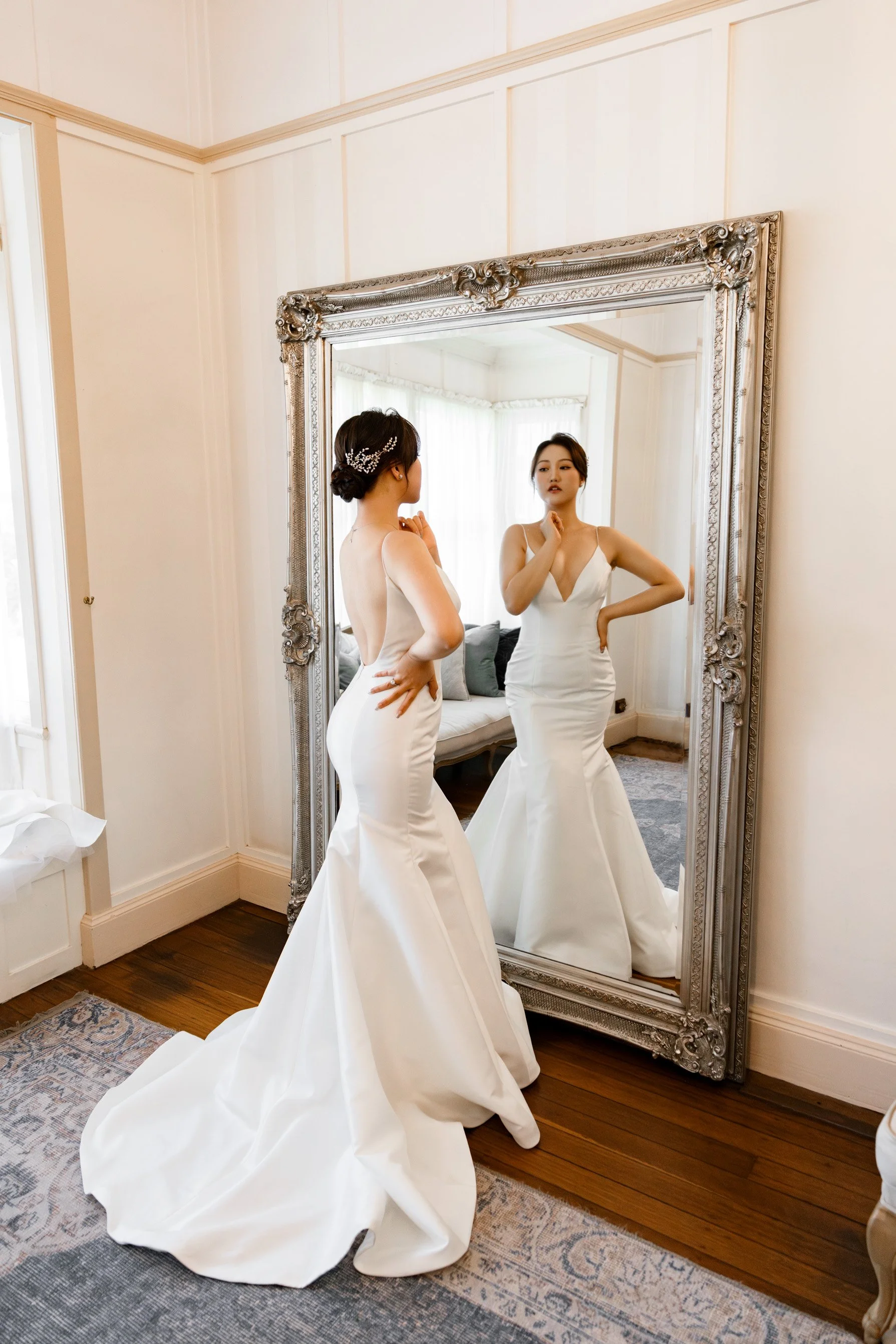 bride look at herself through the mirror when right hand under her chain