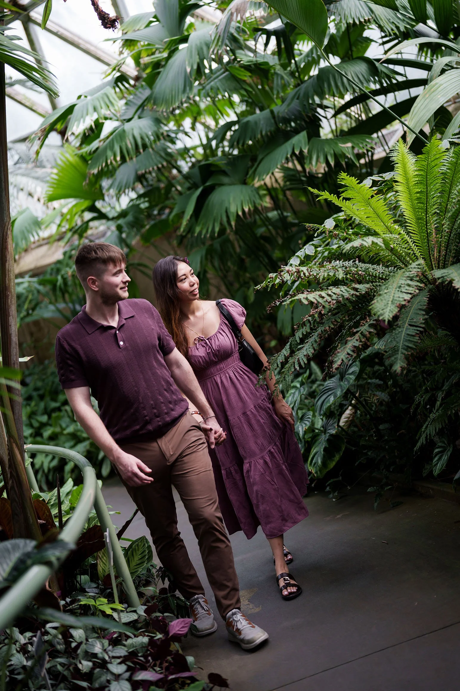They walked hand in hand, their eyes directed toward the greenery ahead.