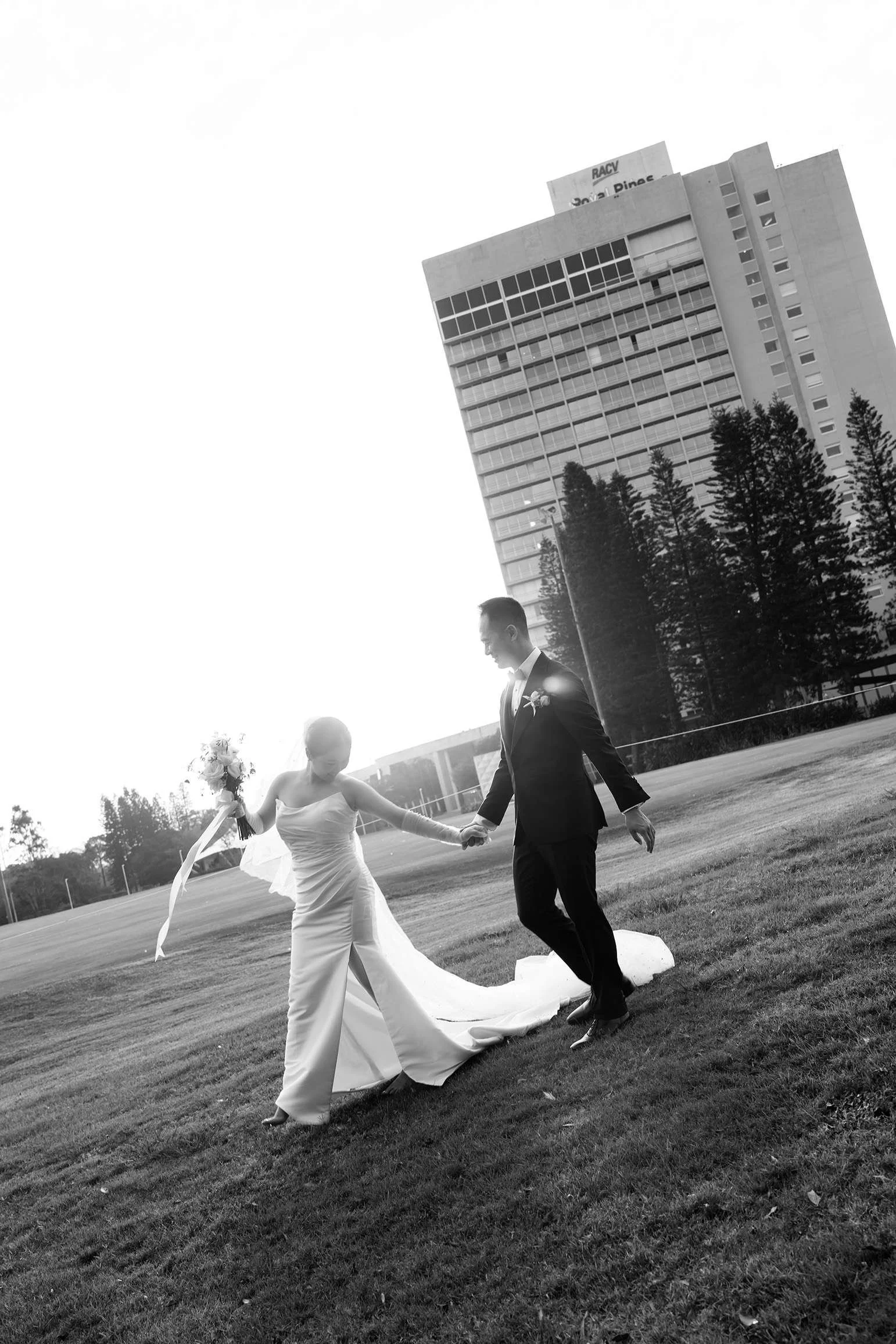 bride Wendy look down to her dress while holding groom Alex's hand and they walking from right to left