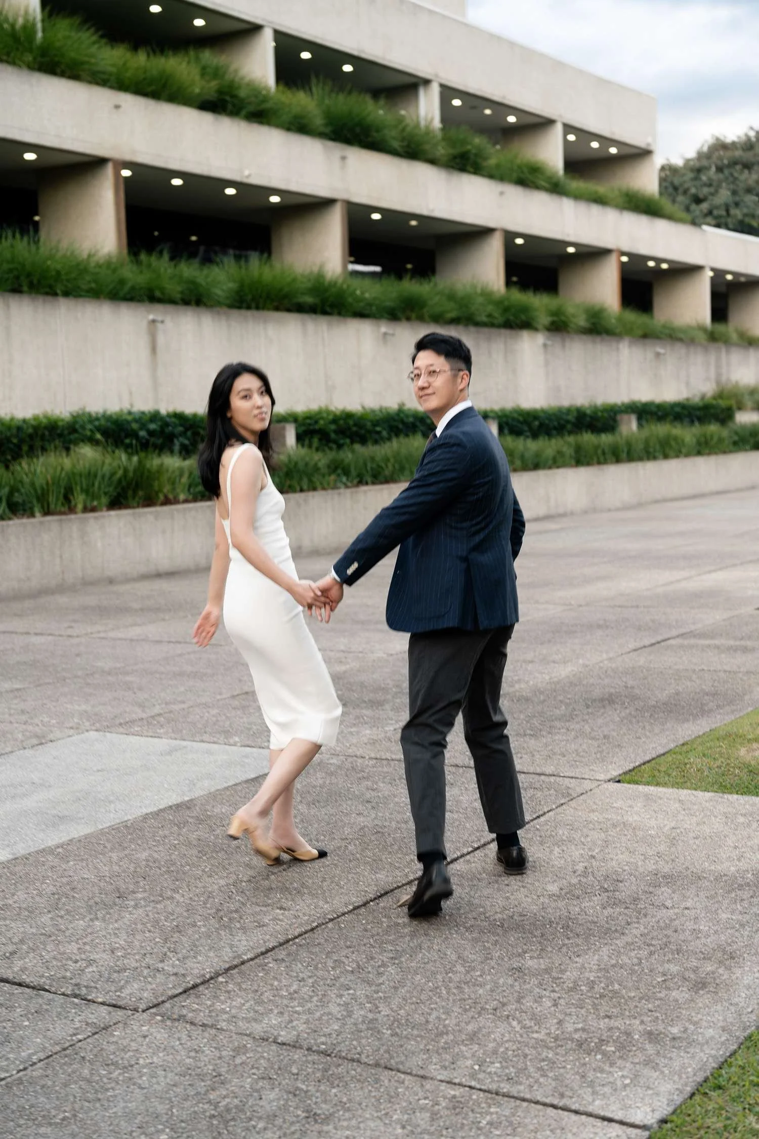 Kath and Dave holding hands, looking back at the camera with smiles, sharing a playful and loving moment together