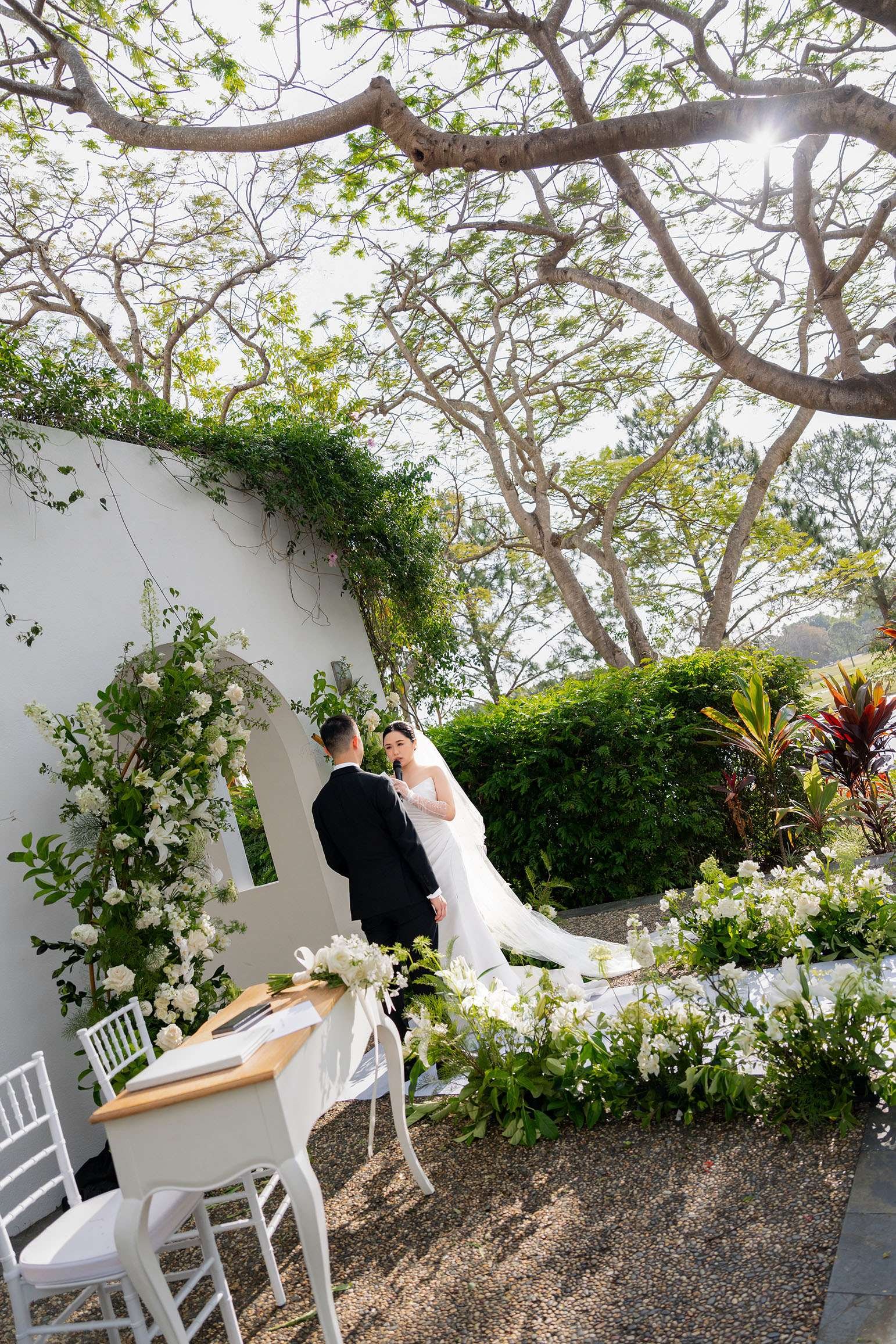 Wendy speak on a mic with her vows while look at groom Alex in wedding ceremony