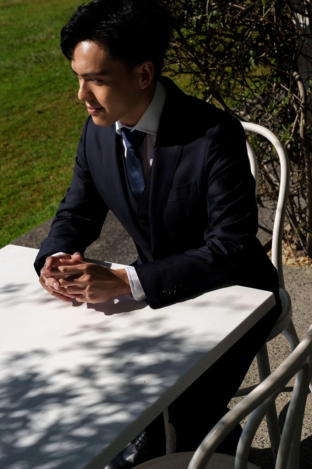 Michael sitting with two hand on a white table