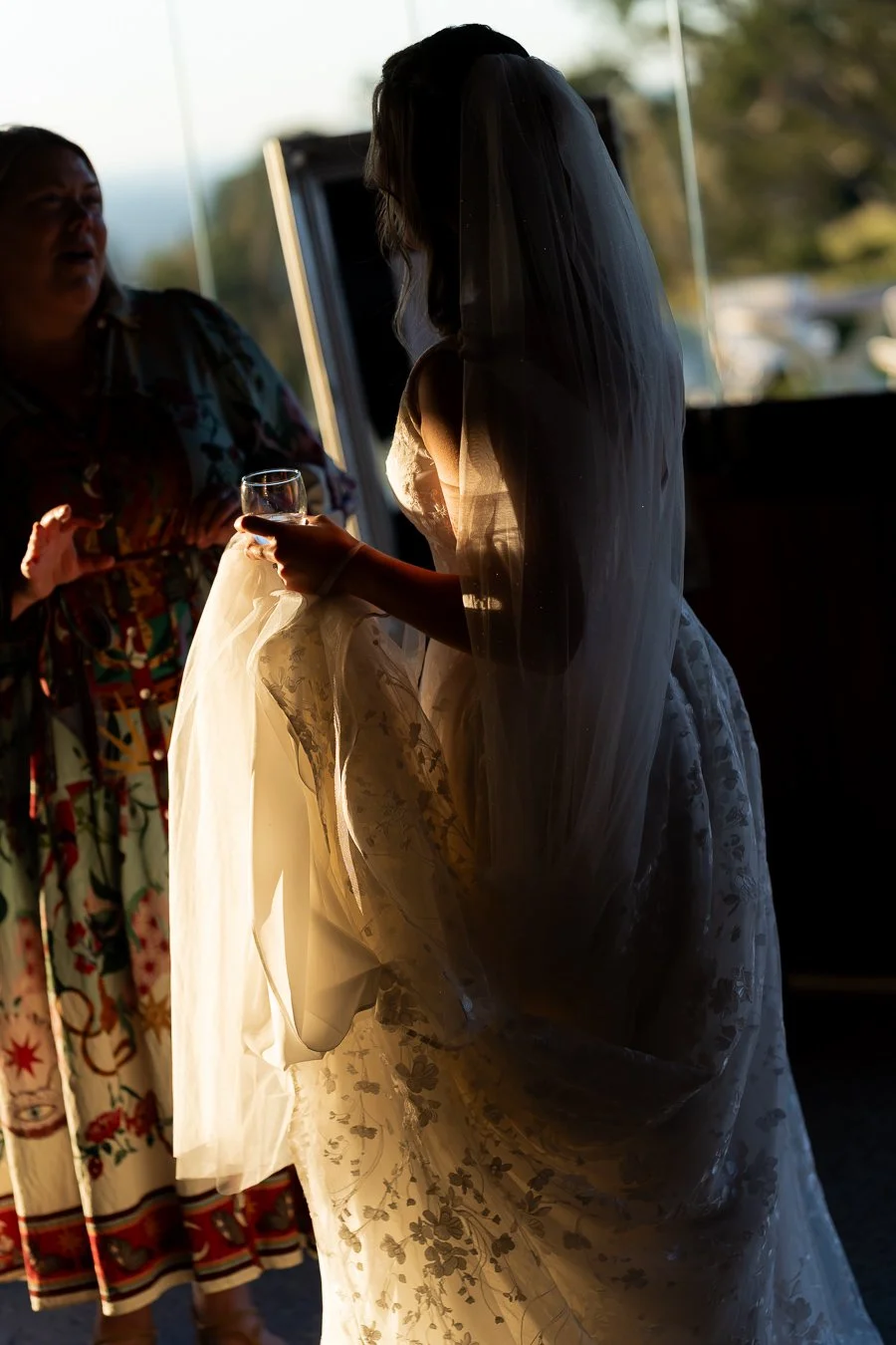 bride Chiarra holding a glass talk to a femle guest