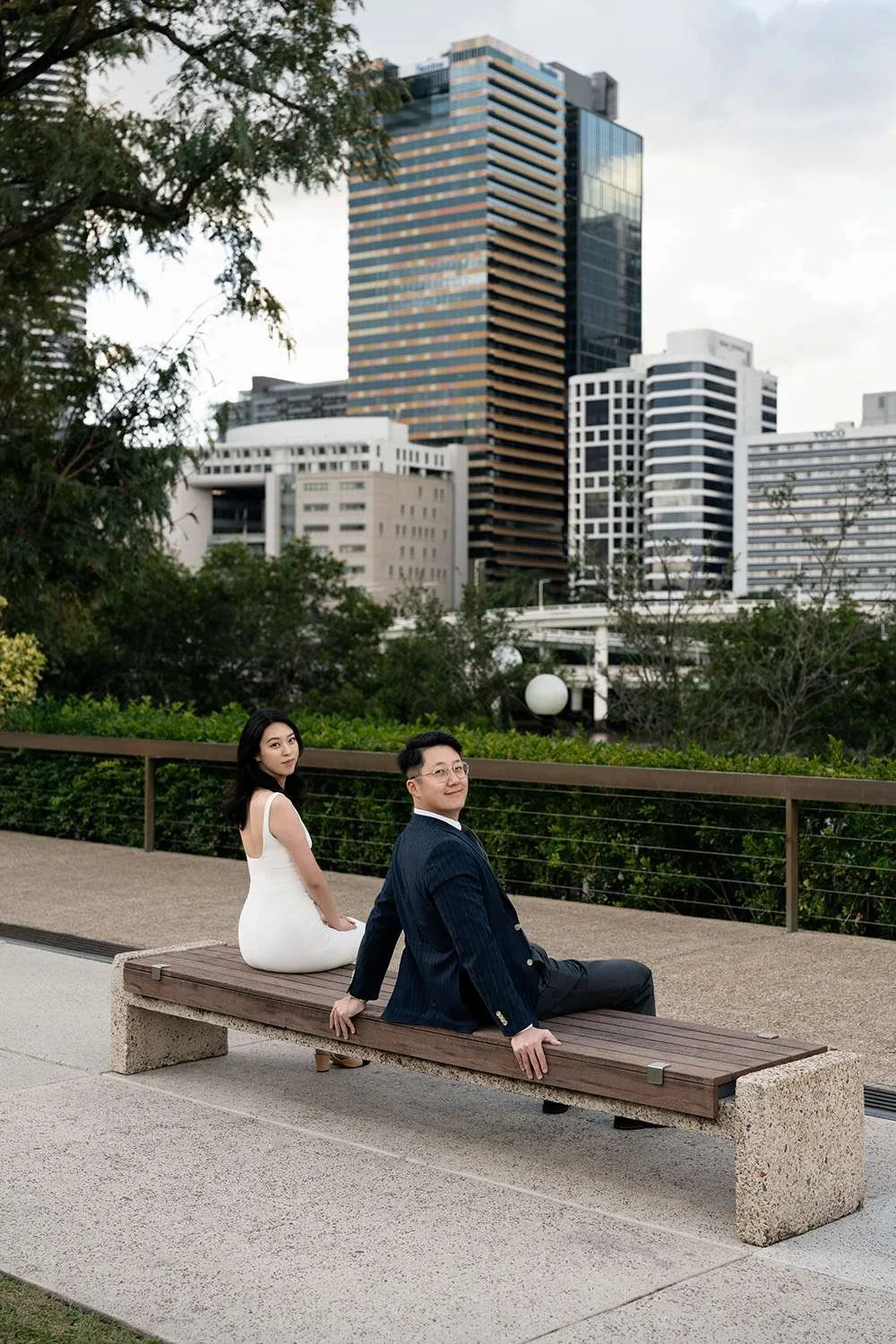 Kath and Dave sitting on a bench, gazing towards Brisbane wedding photographer Whistler, sharing a calm and intimate moment as they take a break from the celebrations