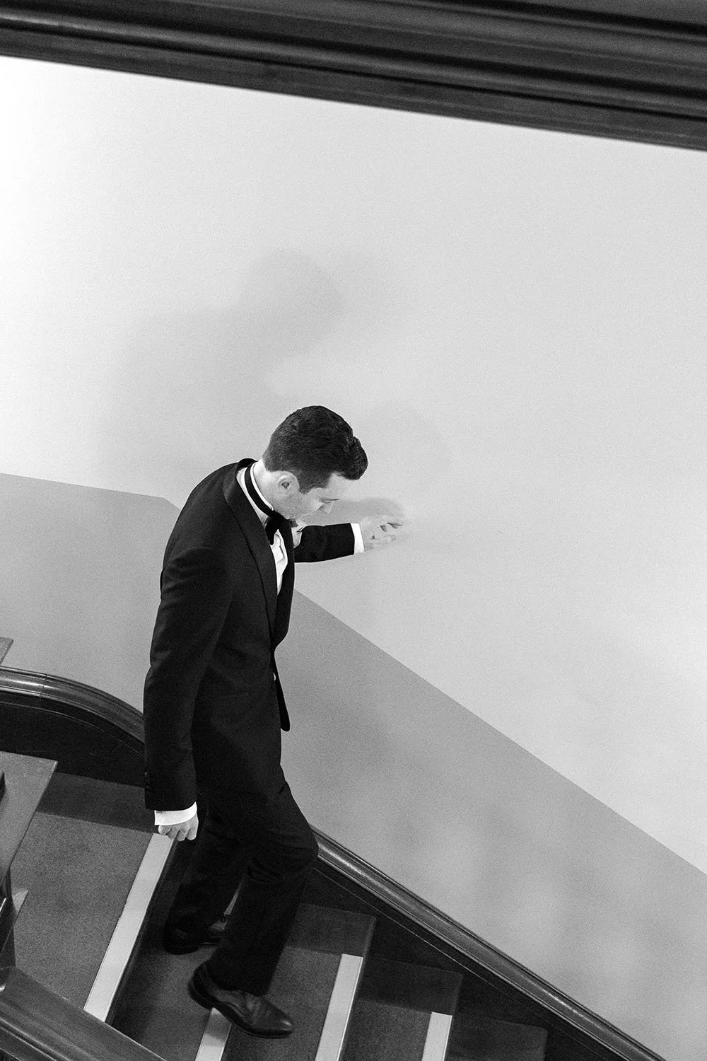 groom Cliffe touching the wall when walking down the stairs
