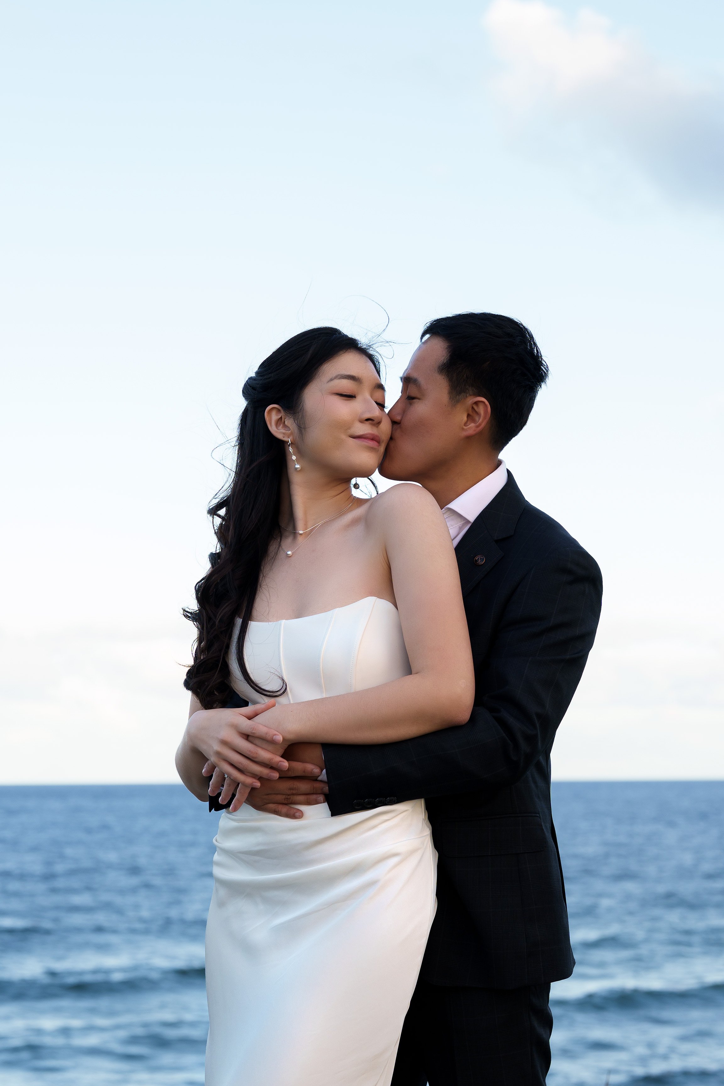 Silva holding Margaret form back and kiss her face, ocean as the background