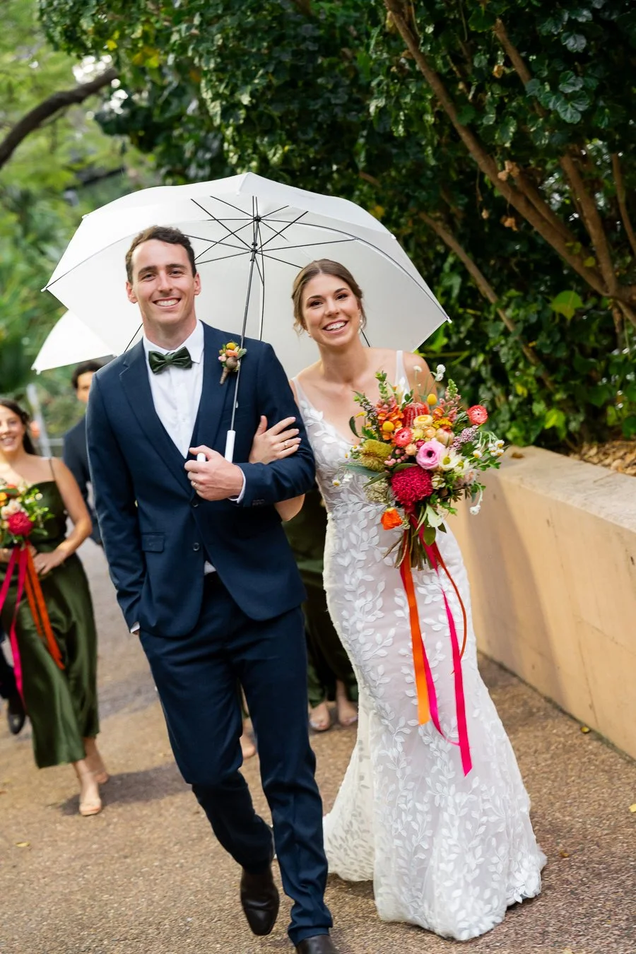 bride Sonya holding groom Giordan's arm walking towards to the Brisbane wedding photographer Whistler Li