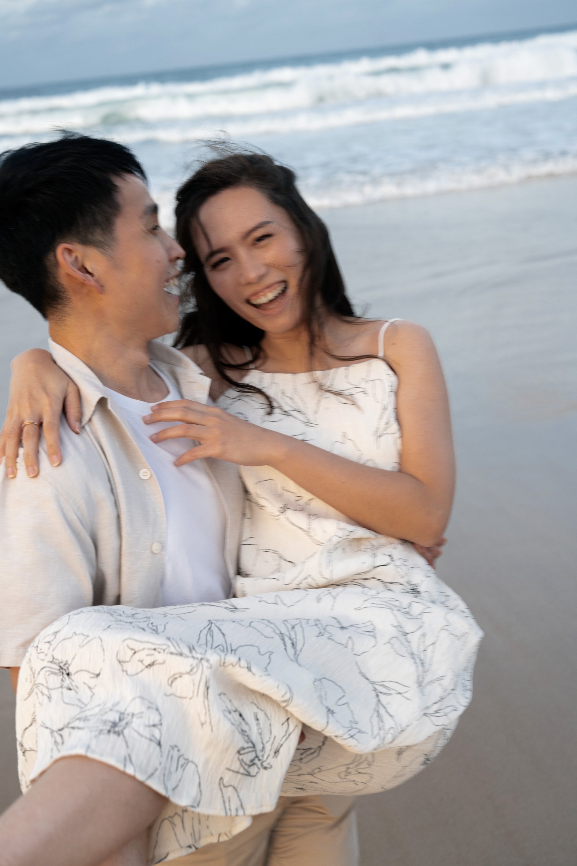 Paul holding Krystel up and she look at the Brisbane wedding photographer Whistler in Gold Coast in their engagement photography session