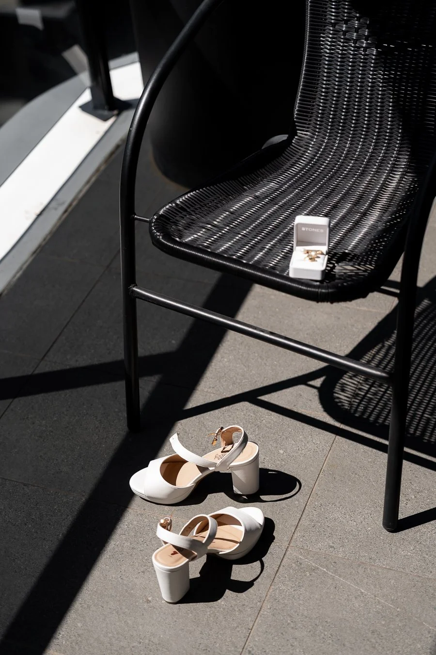 The bride’s shoes were on the floor, and her engagement ring was placed on a chair