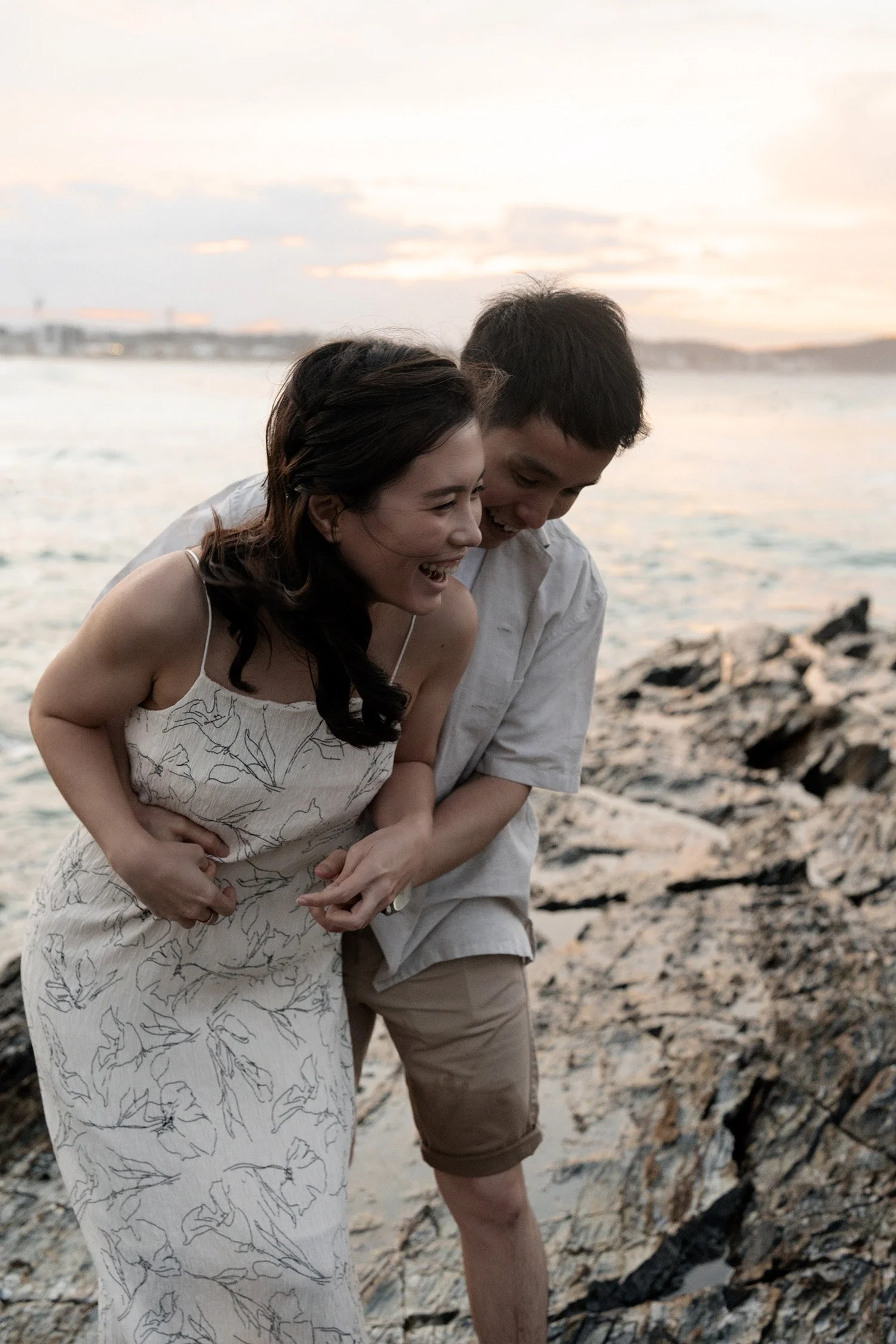 Paul holding Krystel from back and they both laughing in Currumbin Rock
