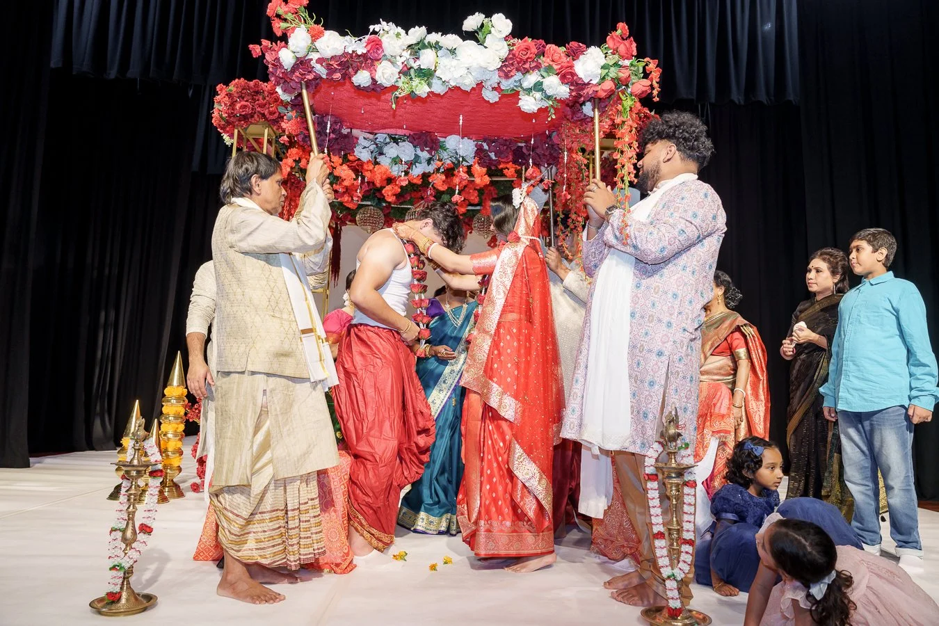 Amrita and Casey changing rose necklace while people around them