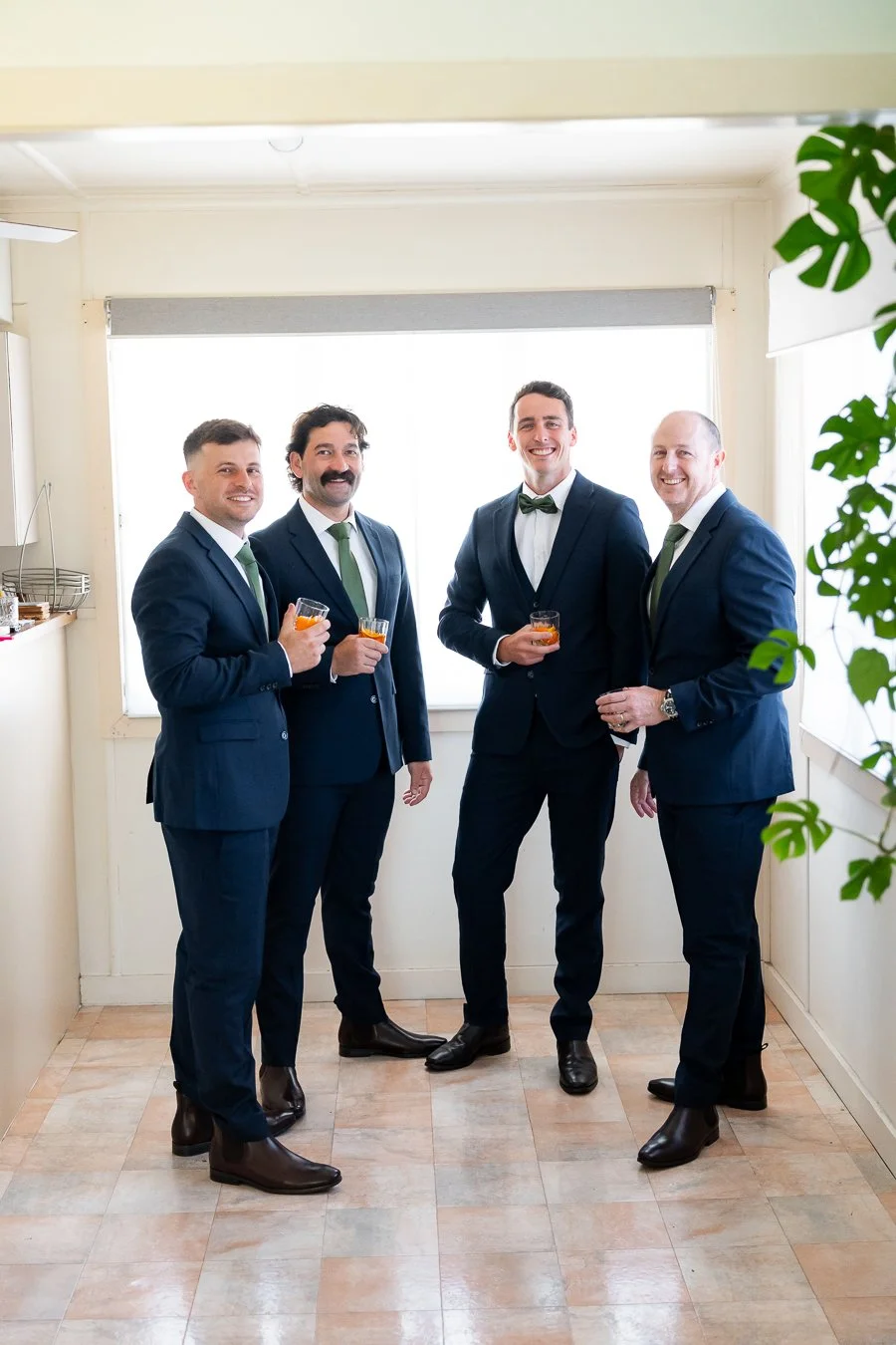 The groom and his groomsmen, dressed in suits and bow ties, held glasses and looked at the Brisbane photographer Whistler Li